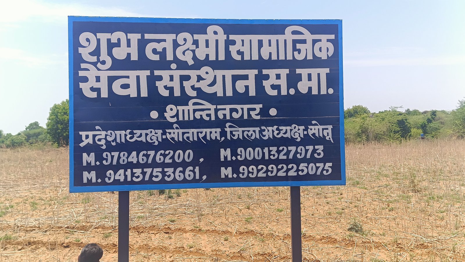 संस्था की जमीन पर बोर्ड लगाते हुए 